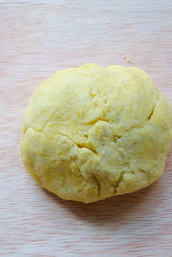 Semolina and water pasta dough rolled into a ball but showing some cracks due to being undermixed.