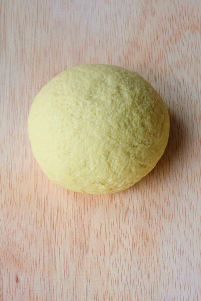 A smooth ball of semolina pasta dough that's been properly mixed and is ready to rest.