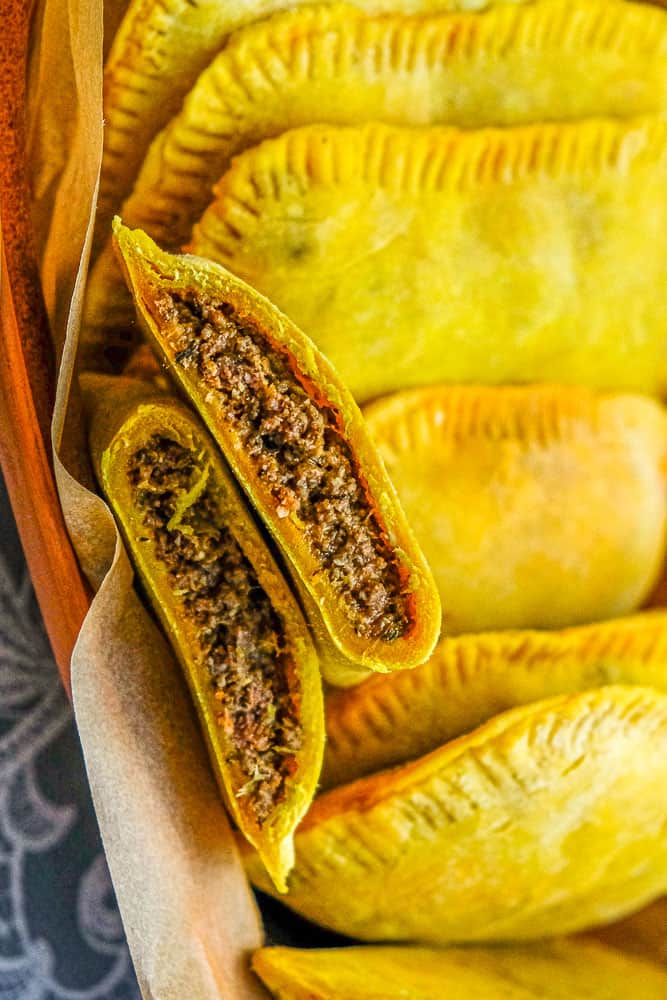 Homemade Jamaican beef patties with rice and peas in the background.