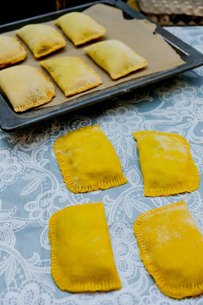 Homemade Jamaican beef patties with rice and peas in the background.