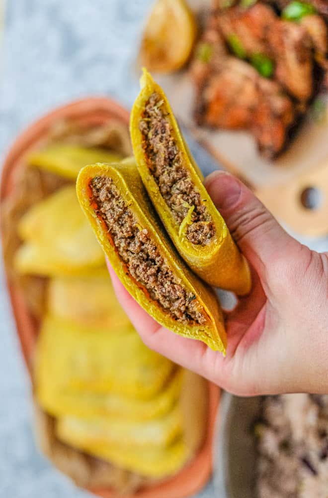 Homemade Jamaican beef patties with rice and peas in the background.