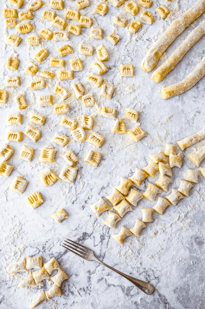 Cutting and shaping homemade potato gnocchi made with leftover mashed potatoes.