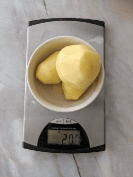 Weighing raw potatoes before boiling for a homemade gnocchi recipe.