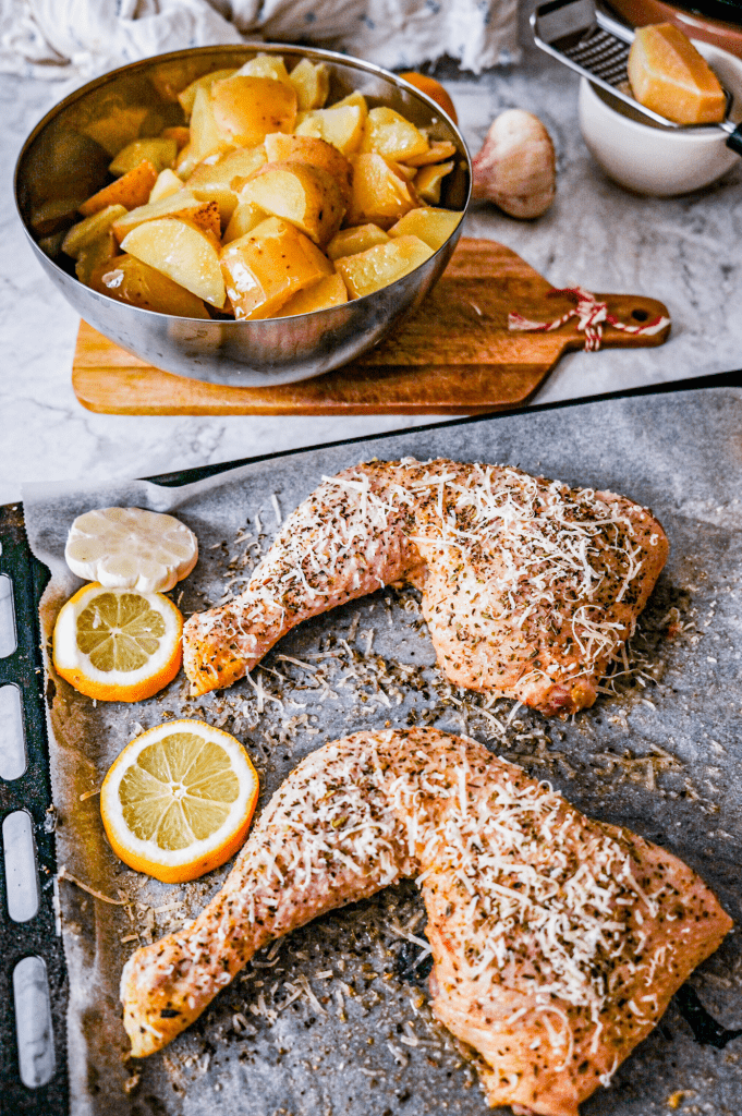 Preparing crispy parmesan and herb chicken quarters with roasted potatoes.