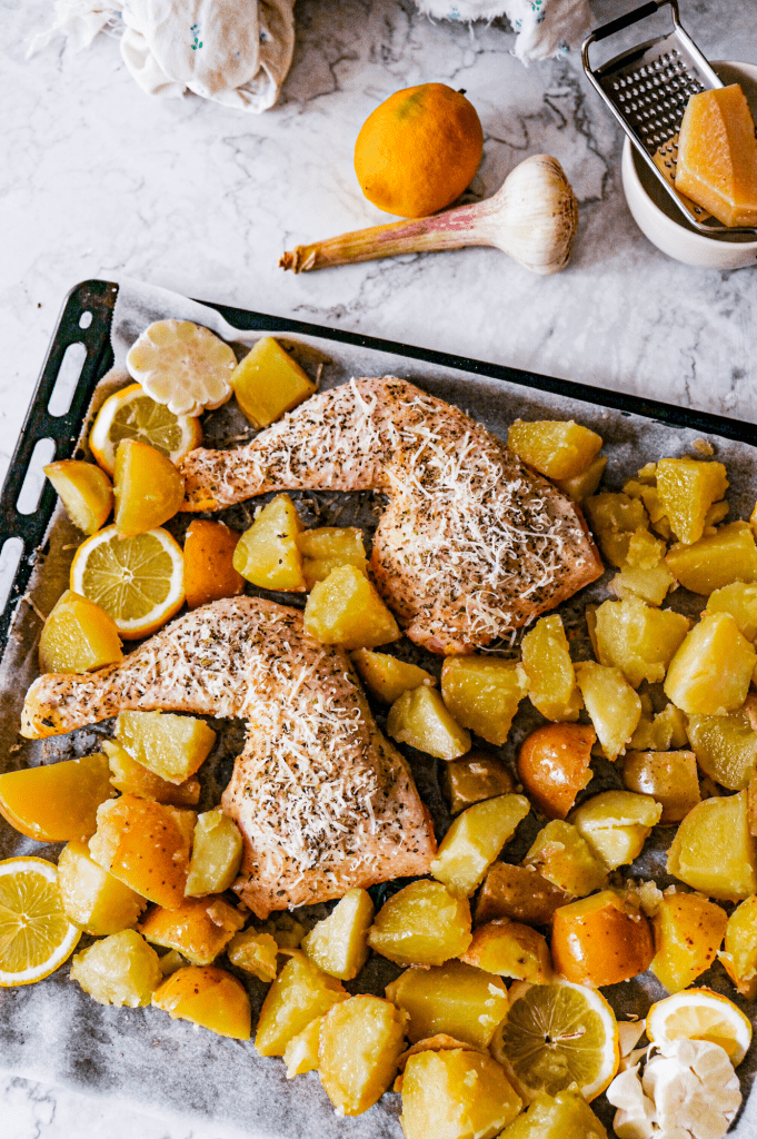 Preparing crispy parmesan and herb chicken quarters with roasted potatoes.