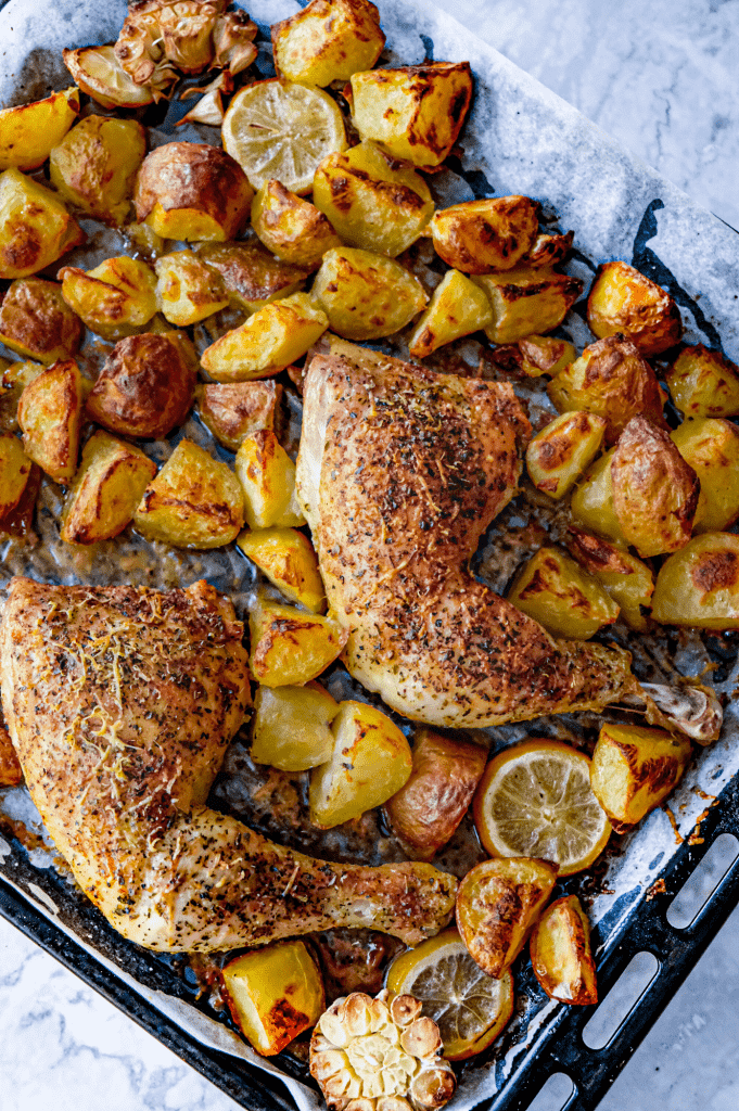 Crispy sheet pan parmesan chicken thighs and potatoes with garlic, lemon and herbs
