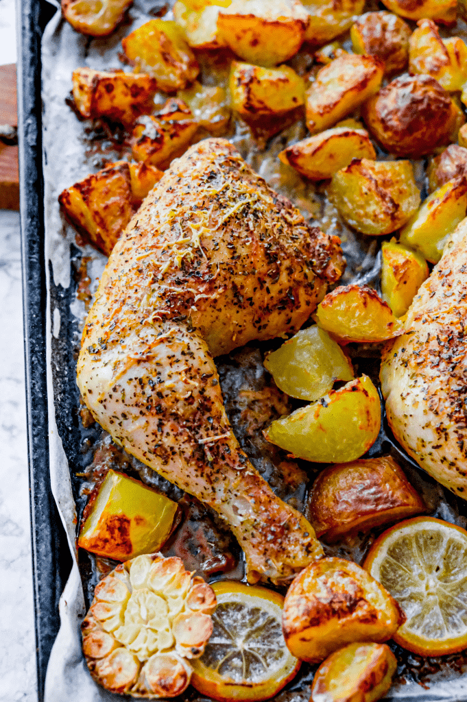 Crispy sheet pan parmesan chicken thighs and potatoes with garlic, lemon and herbs