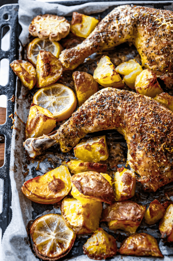 Crispy sheet pan parmesan chicken thighs and potatoes with garlic, lemon and herbs