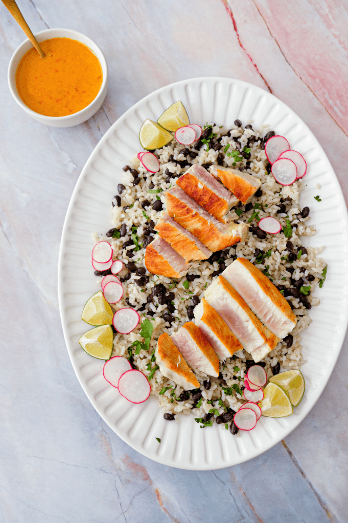 Tuna steak served over coconut lime rice with black beans and cilantro