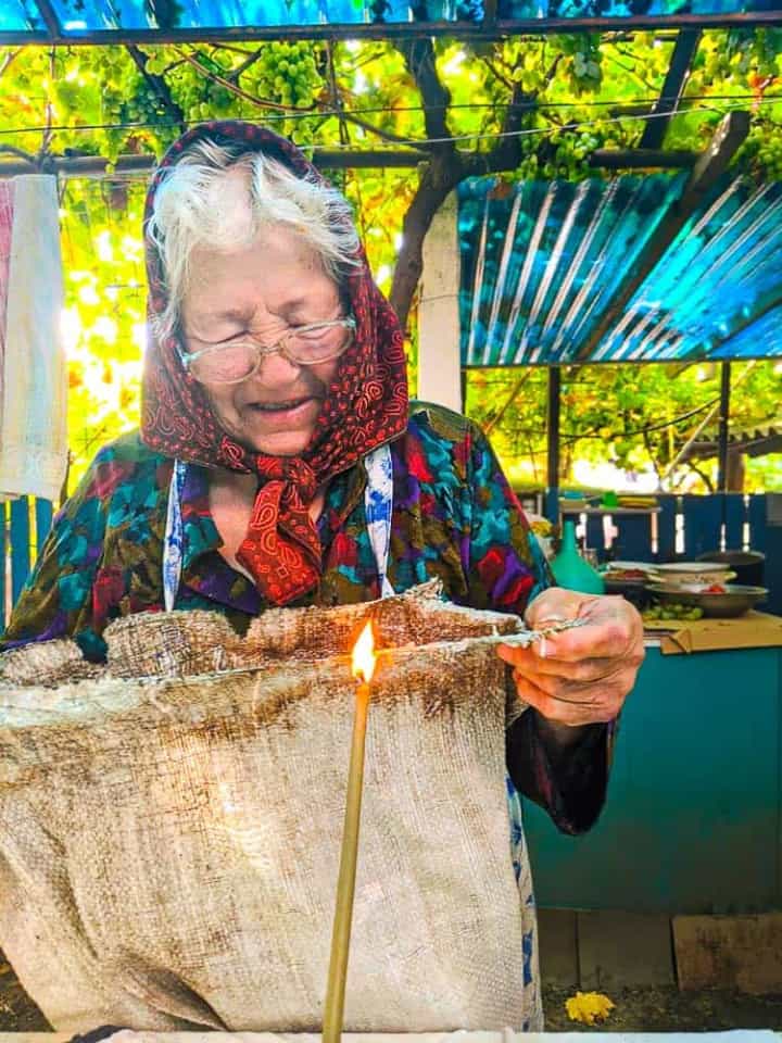 As a child my grandmother lived through a years long drought and famine that instilled in her a lifelong devotion to thrift. In the photo above, taken the day before the annual grape harvest, she’s using a beeswax candle to seal off the frayed edges of a large sac that would be used for the second or third time to collect grapes from our small family vineyard. She’s smiling as she tells us a joke or bit of some village gossip.