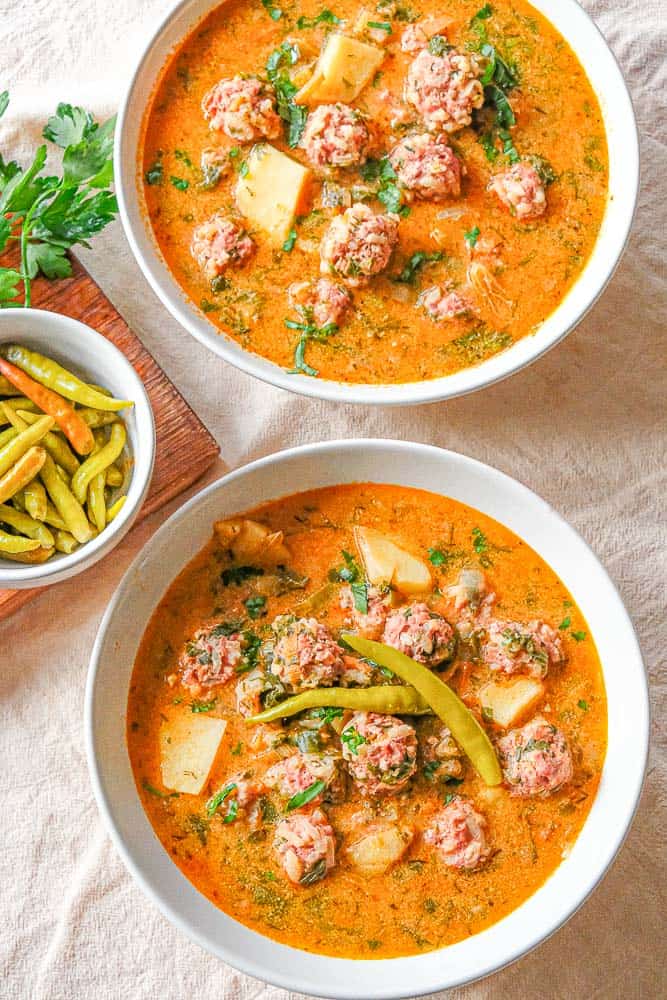 This classic Romanian soup features hearty porcupine meatballs swimming in a creamy and flavourful broth dotted with diced veggies and fresh herbs like lovage, parsley and dill. Serve with hot pickled peppers and crusty bread for a perfect cold weather meal.