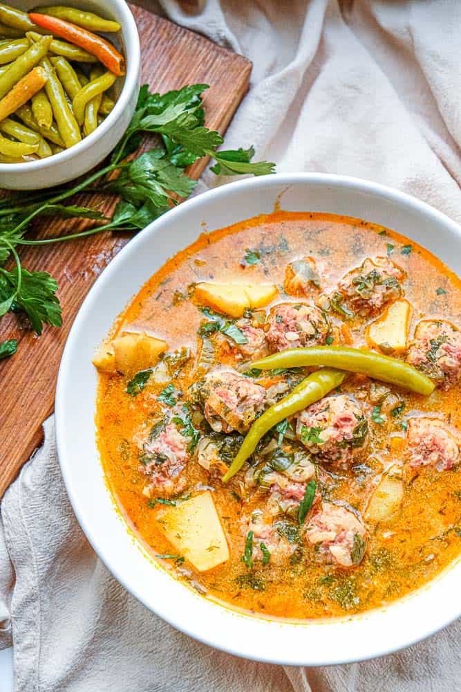 This classic Romanian soup features hearty porcupine meatballs swimming in a creamy and flavourful broth dotted with diced veggies and fresh herbs like lovage, parsley and dill. Serve with hot pickled peppers and crusty bread for a perfect cold weather meal.