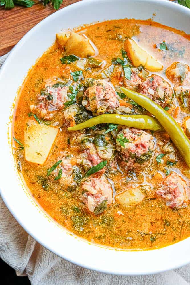 This classic Romanian soup features hearty porcupine meatballs swimming in a creamy and flavourful broth dotted with diced veggies and fresh herbs like lovage, parsley and dill. Serve with hot pickled peppers and crusty bread for a perfect cold weather meal.