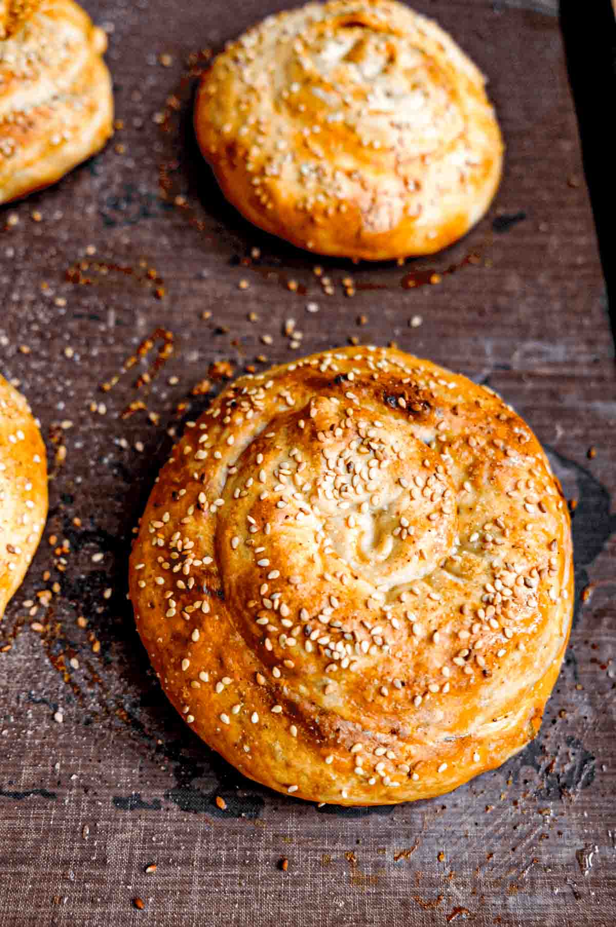 Golden brown phyllo dough spirals with sesame seeds sprinkled on swirly tops.