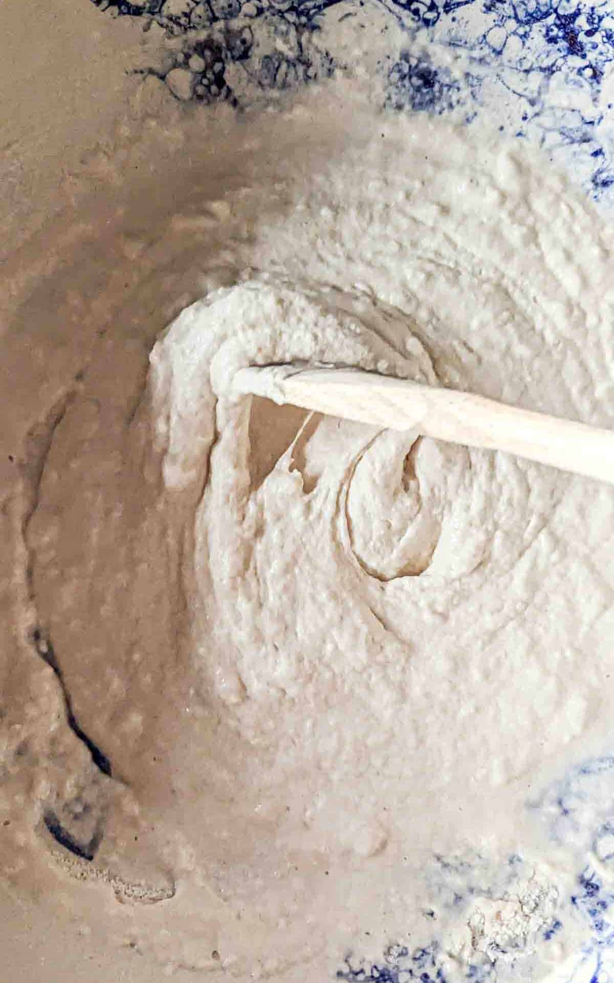 Stirring bread ingredients with a wooden spoon