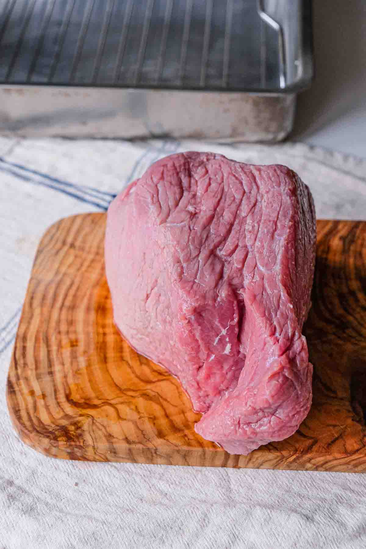 A large veal loin or veal rump on a cutting board.