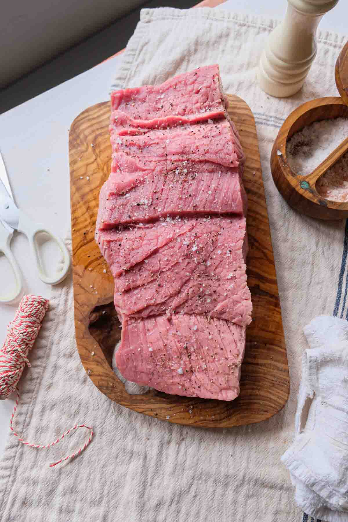 A veal rump cut so it lays flat and then salted and peppered.