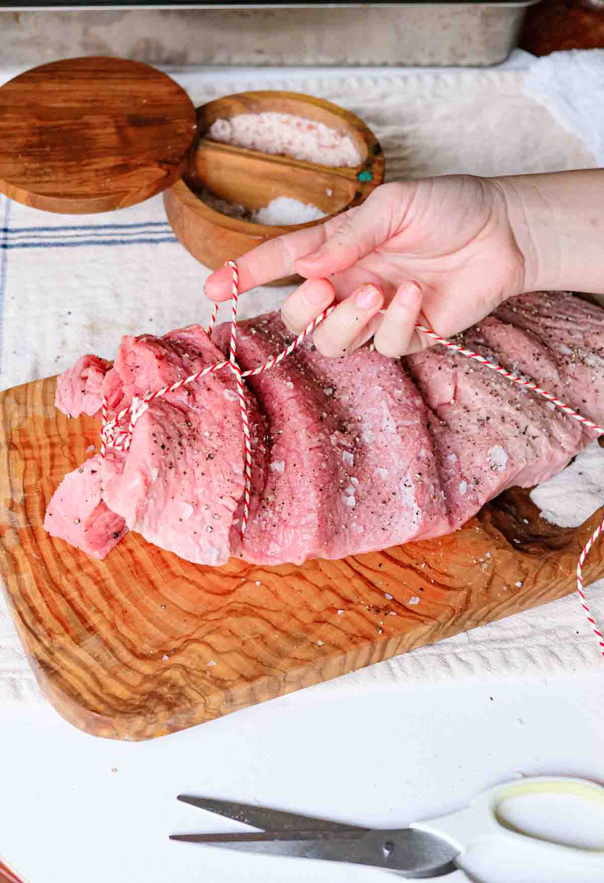 A seasoned veal rump cut so it lays flat and trussed with cooking string.