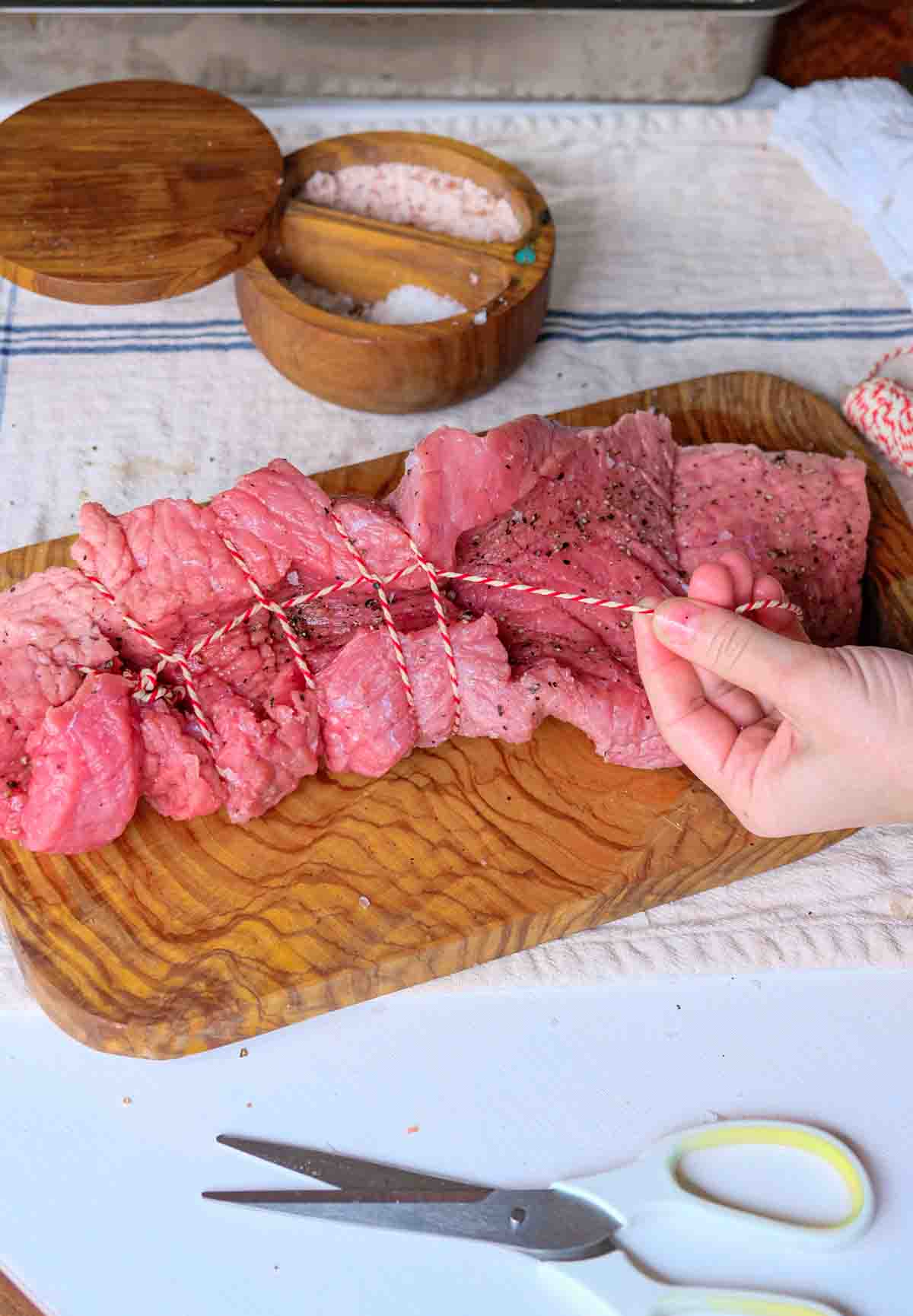 A loin of veal being trussed.