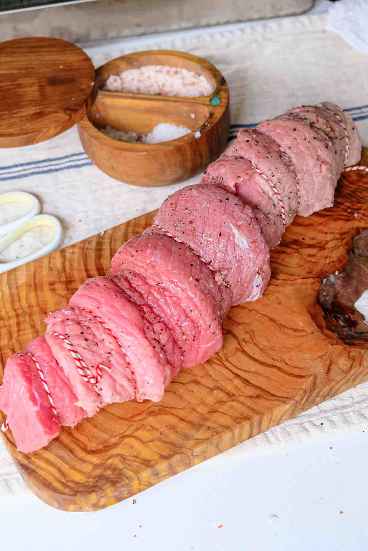 An uncooked trussed veal roast on a cutting board.