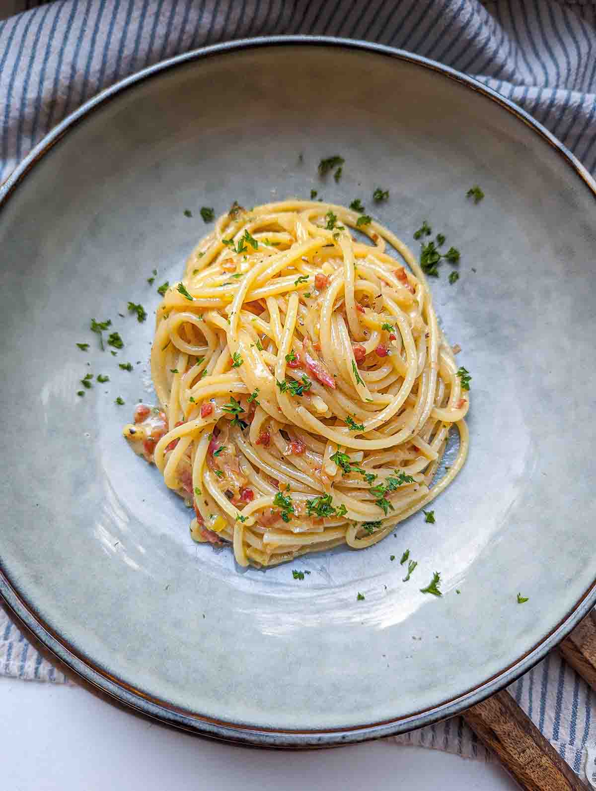 an overhead view of the finished pasta in a pasta bowl garnished with fresh parsley