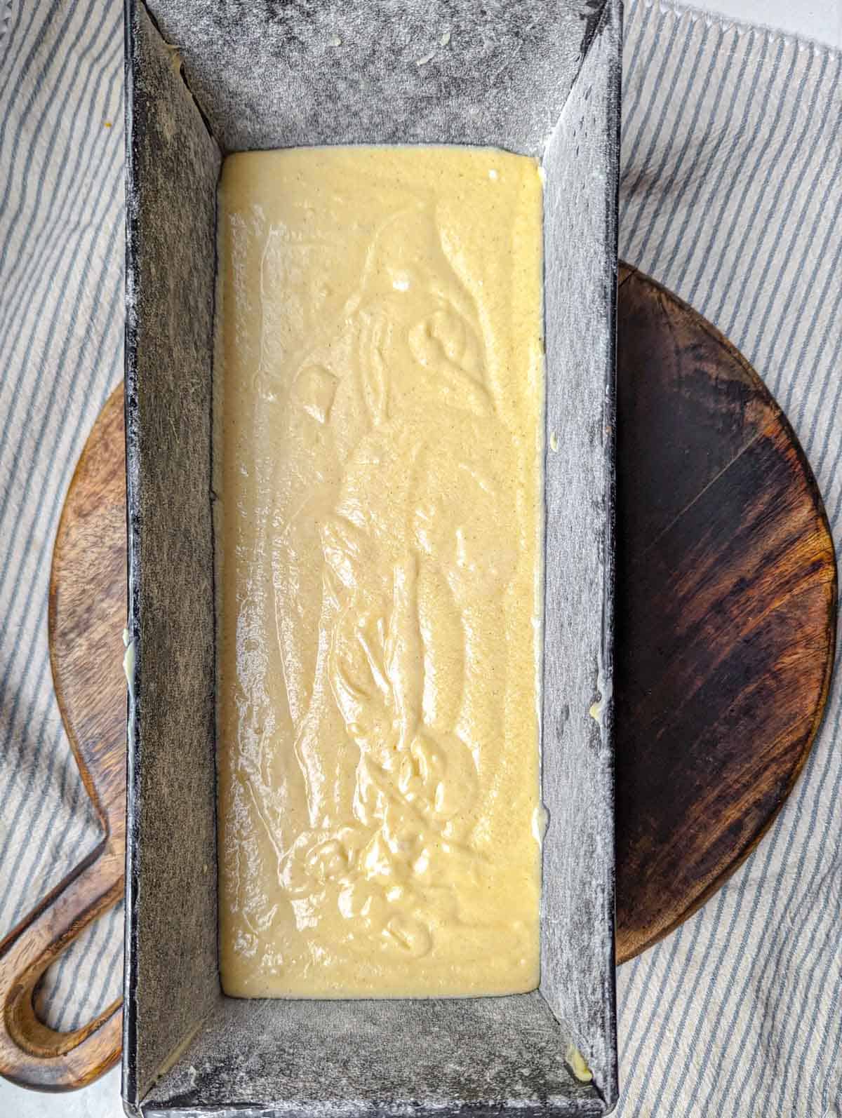 Cake batter in a prepared loaf pan.