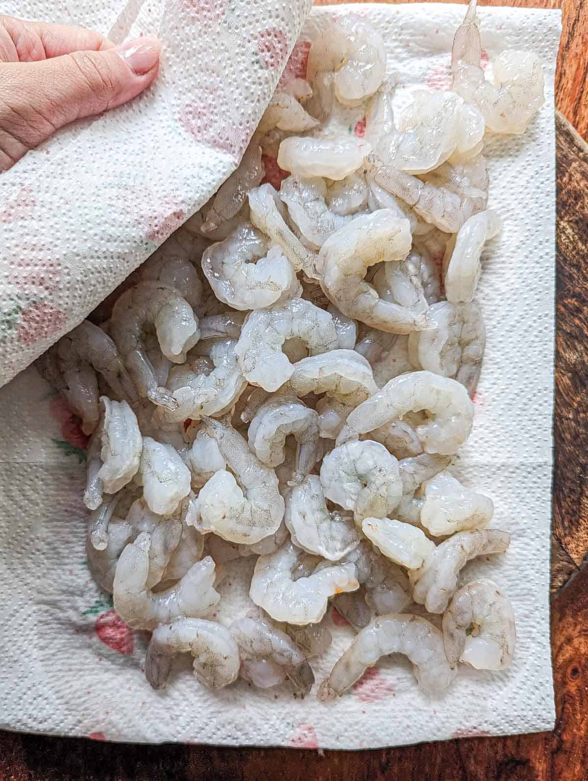 Drying the shrimp with paper towel before cooking.