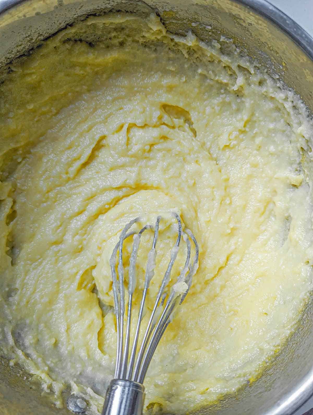 whisking polenta after adding heavy cream and parmesan
