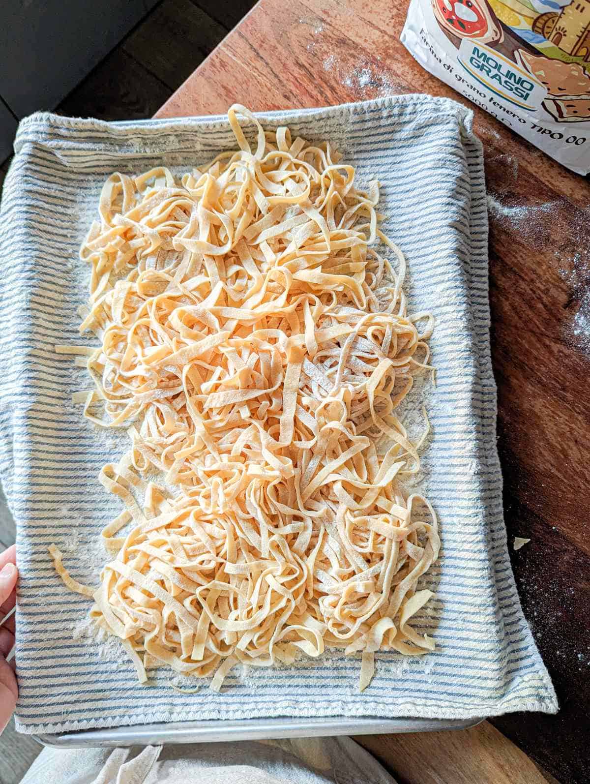 A tray of hand rolled and hand cut tagliatelle pasta.