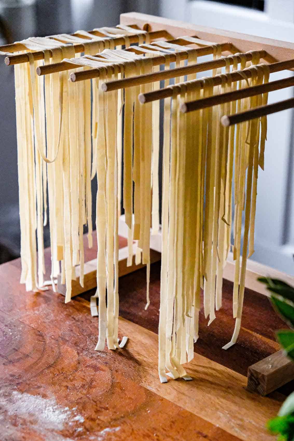 Hand cut pasta drying on a rack.