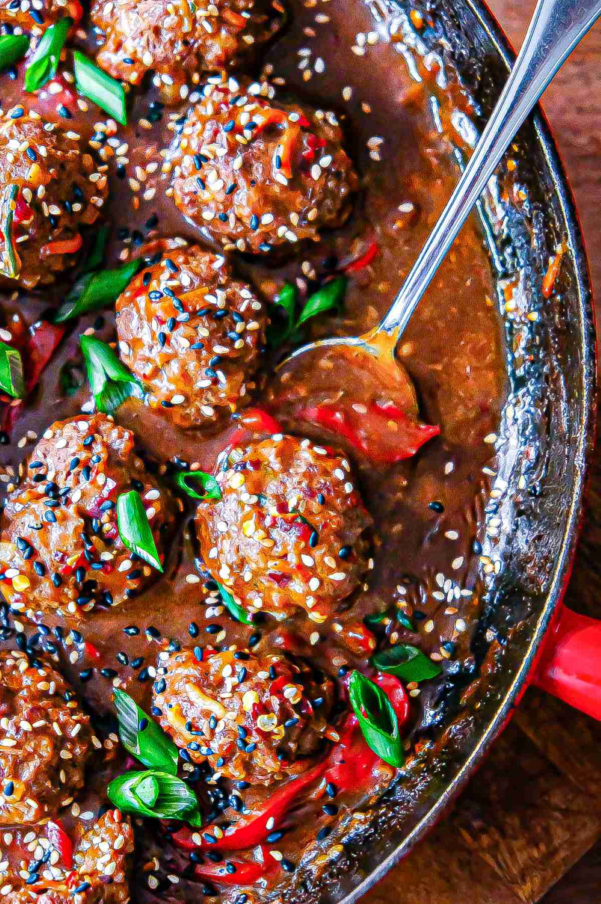 Hoisin meatballs in a skillet with lots of sweet and spicy sauce.