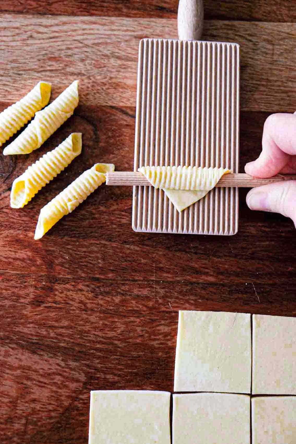 Using a ridged pasta board to make ridges on garganelli pasta.