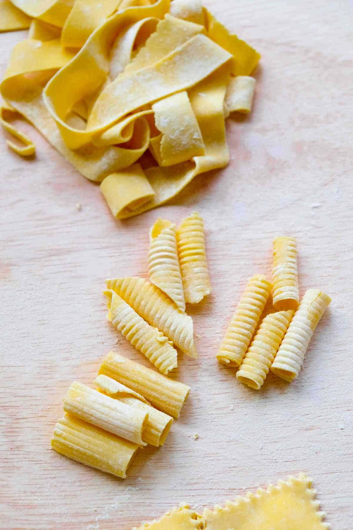 Different pasta shapes are shown. From the top there is pappardelle, then rigatoni, garganelli and macaroni.