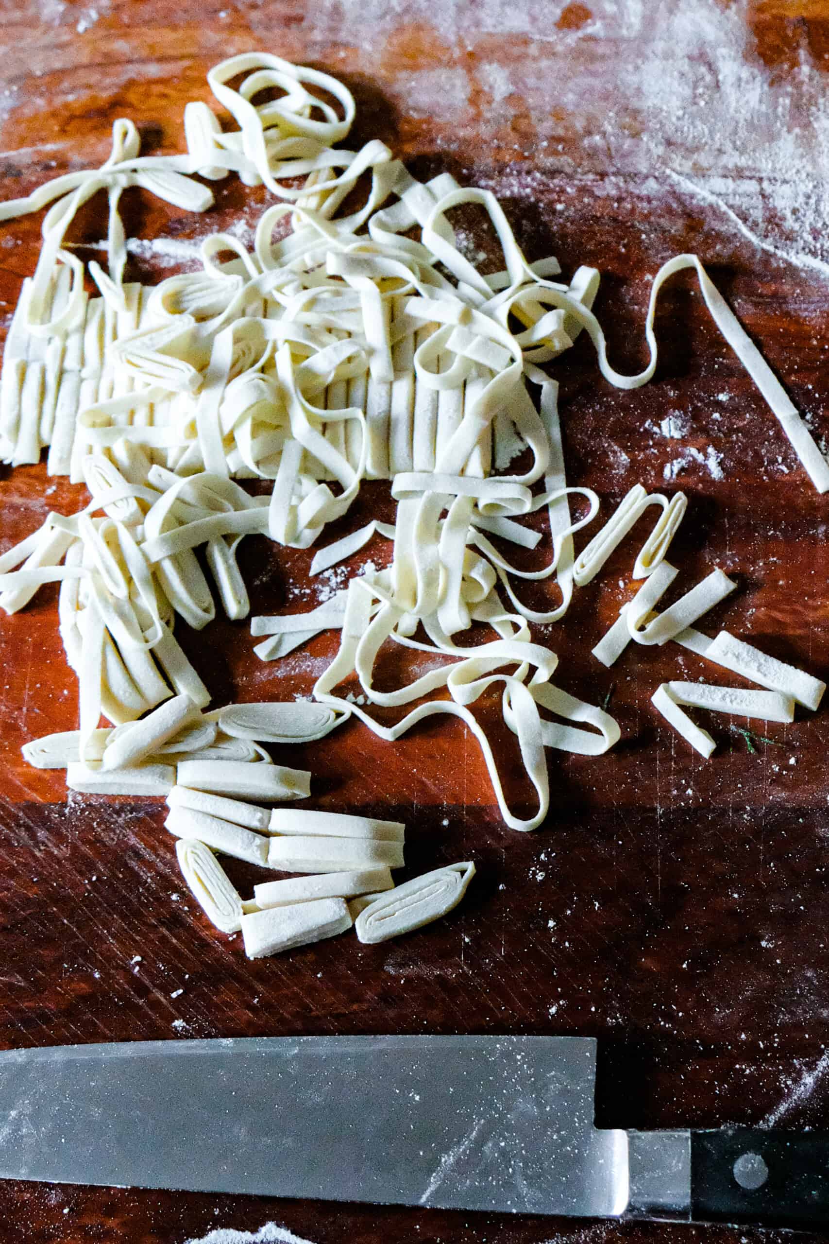 Rolled pasta being cut into tagliatelle.