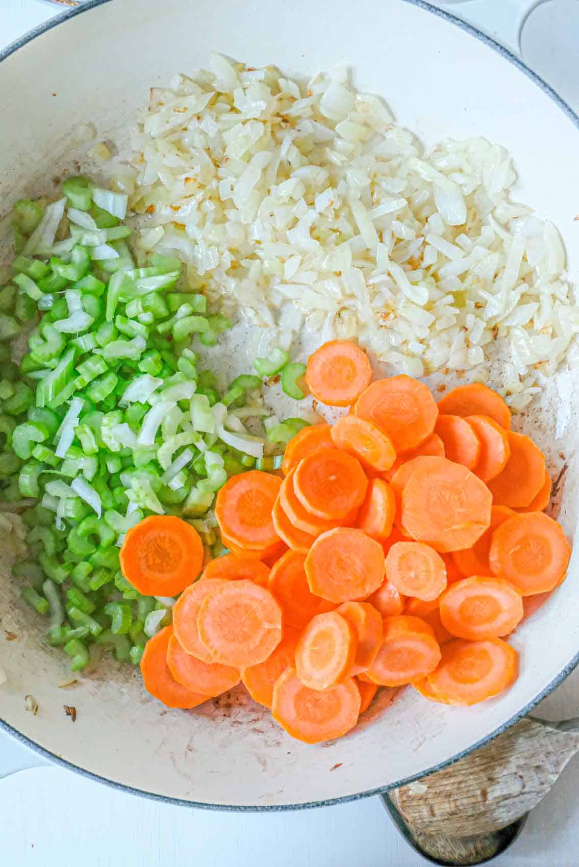 Browned onions with carrots and celery in a pan.