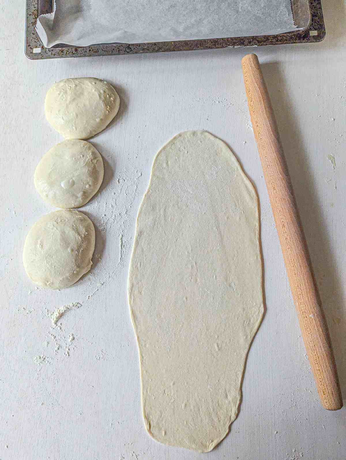 dough balls and a piece of rolled out dough