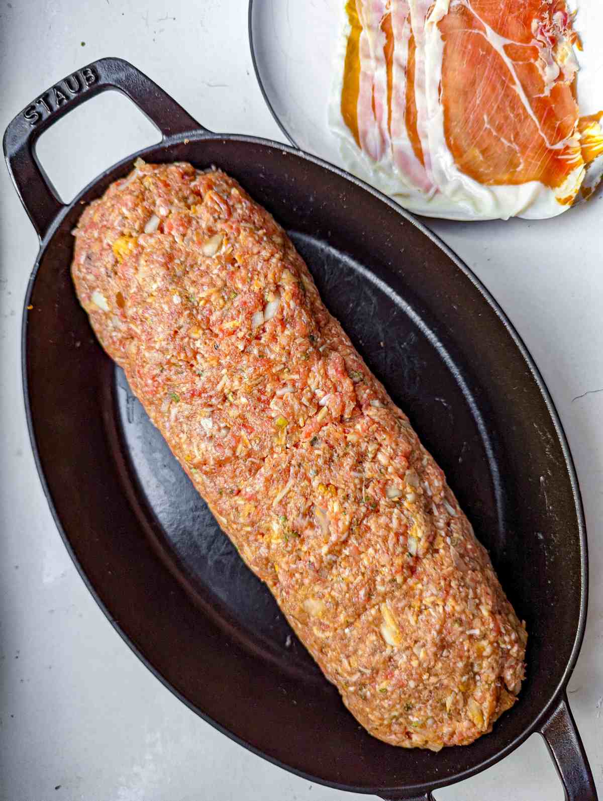 shaped meatloaf form in roasting pan before wrapping in prosciutto