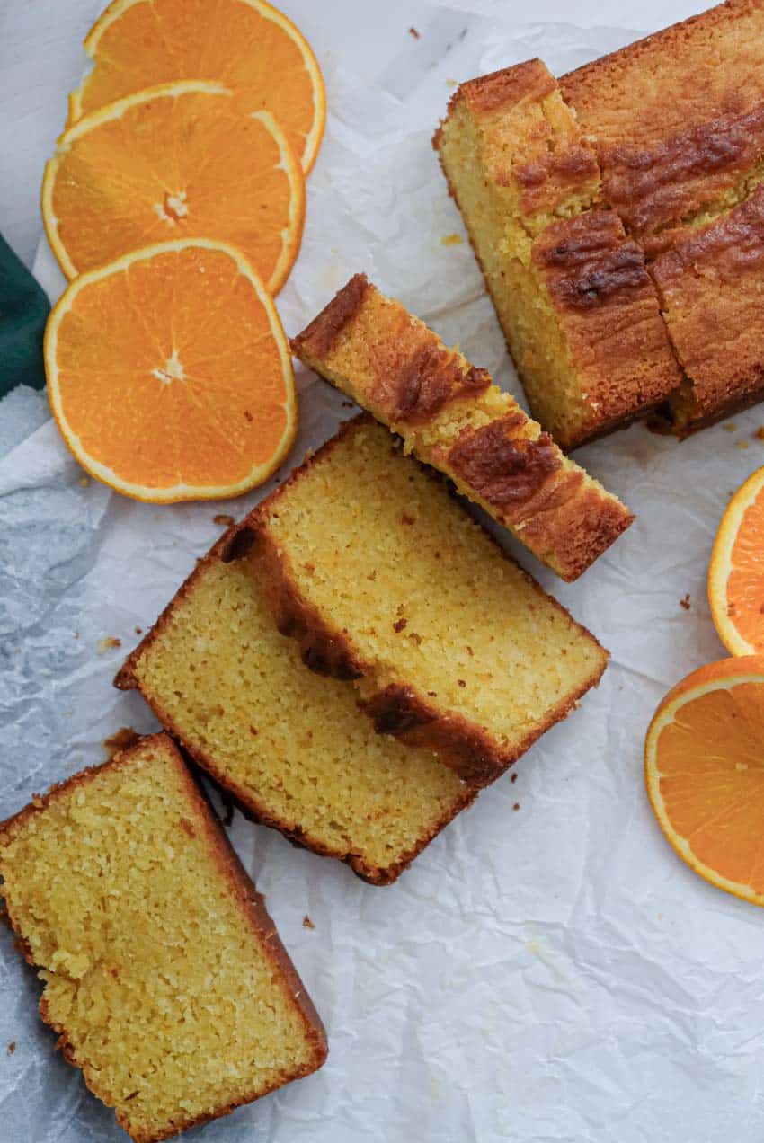 slices of orange cake and oranges on parchment paper