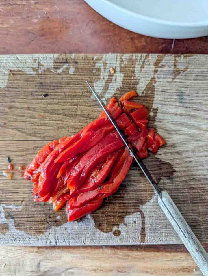cutting roasted red pepper into small cubes
