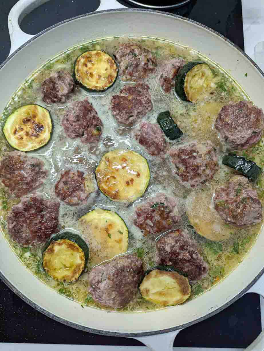 meatballs and zucchini in pot with orzo