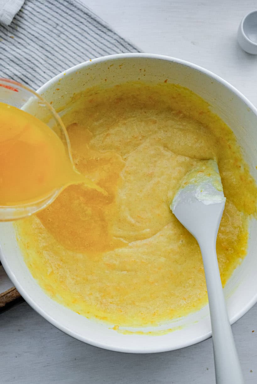 Orange juice being poured into the batter.