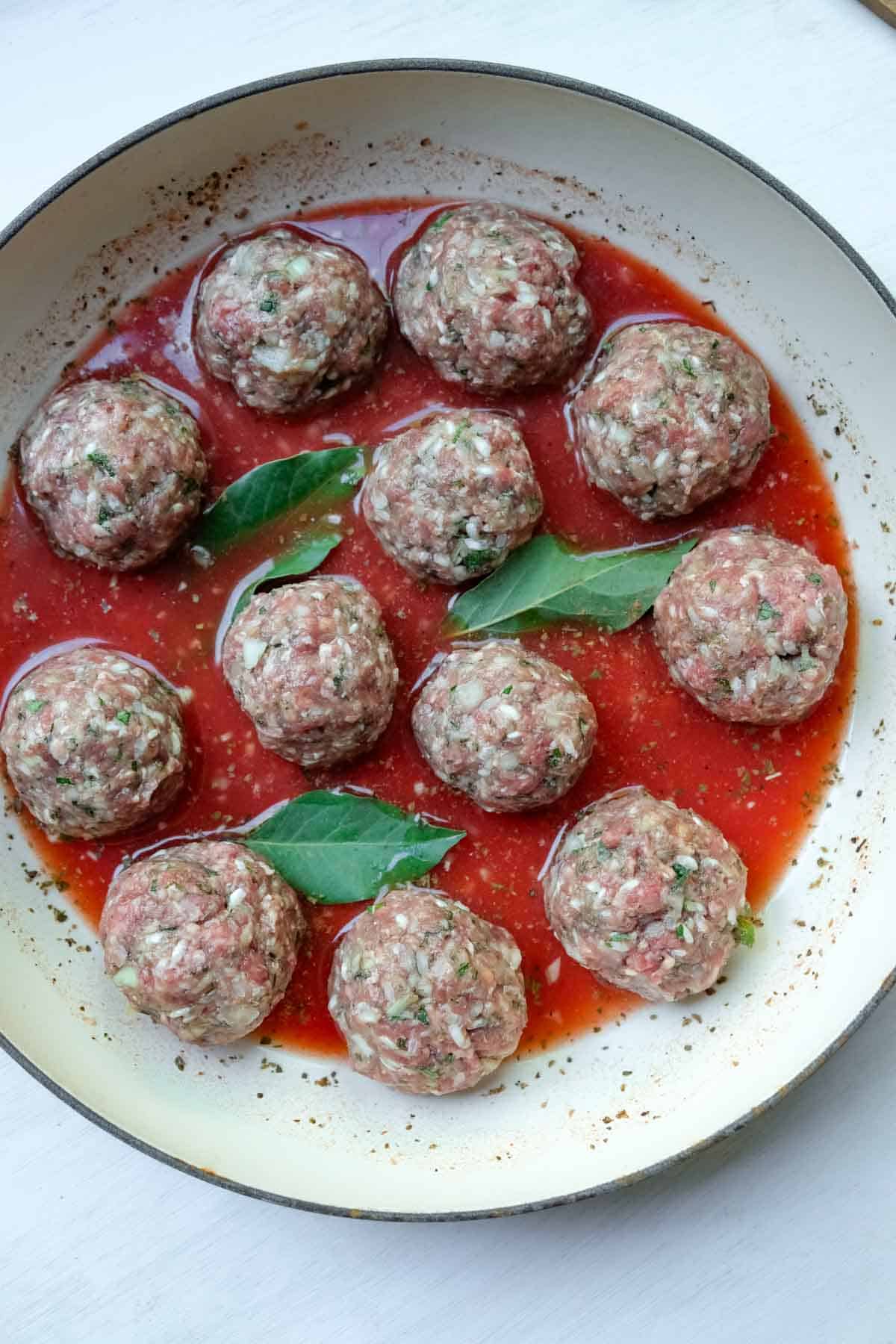 rice meatballs in pan with bay leaves