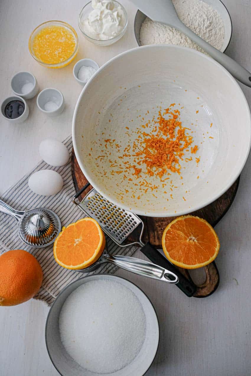A bowl of orange juice and other ingredients on a table.