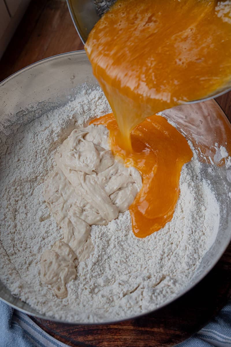 pouring wet ingredients over dry ingredients for cozonac