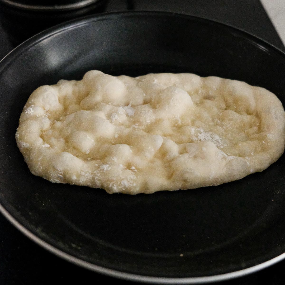 puffed pita bun in skillet