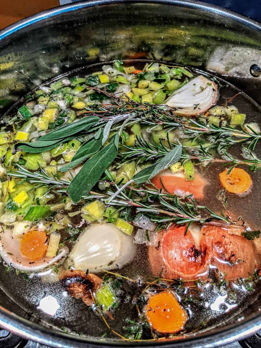 browned aromatics and herbs in soup pot